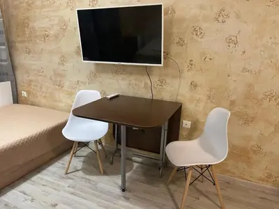 a table with two chairs and a television on a wall at Colonel apartment 958 in Sofia