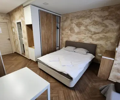 a small bedroom with a bed and a table at Colonel apartment Luxury in Sofia