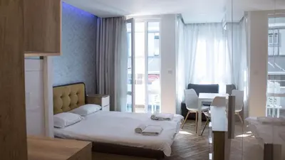 a bedroom with a bed and a dining room with a table at Colonel apartment Diamond in Sofia