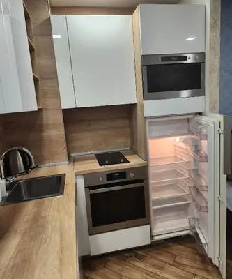 a kitchen with white cabinets and an open refrigerator at Colonel apartment Diamond in Sofia