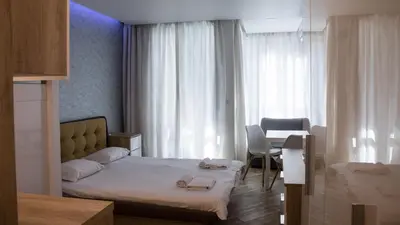 a bedroom with a bed and a table with a chair at Colonel apartment Diamond in Sofia