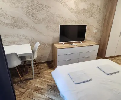 a room with two beds and a tv and a table at Colonel apartment Diamond in Sofia