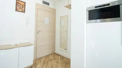 a small kitchen with white walls and wooden floors at Colonel apartment dream in Sofia