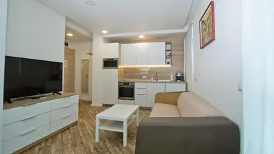 a living room with a couch and a tv and a kitchen at Colonel apartment dream in Sofia