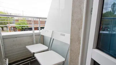 a balcony with two chairs and a window at Colonel apartment Bijou in Sofia