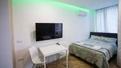 a small room with a bed and a table and a tv at Colonel apartment Bijou in Sofia