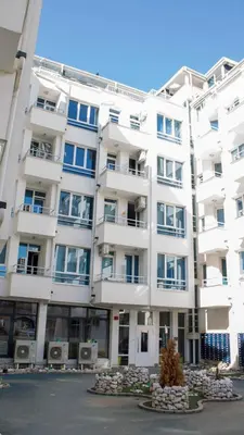 a large white apartment building with a tree in front of it at Colonel apartment Relax in Sofia