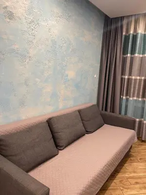a living room with a couch in front of a painting at Colonel apartment Select in Sofia