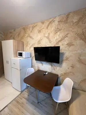 a dining room with a table and a television on a wall at Colonel apartment 937 in Sofia