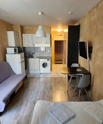 a small living room with a table and a kitchen at Colonel apartment 953 in Sofia