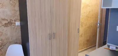a bathroom with a wooden cabinet next to a toilet at Colonel apartment 954 in Sofia