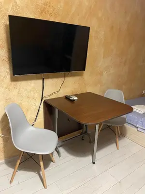 a table with two chairs and a television on a wall at Colonel apartment 955 in Sofia