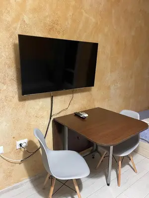 a table with two chairs and a television on a wall at Colonel apartment 955 in Sofia