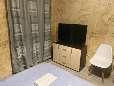 a living room with a tv and a white chair at Colonel apartment 956 in Sofia