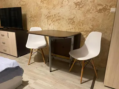 a table and two white chairs in a room at Colonel apartment 956 in Sofia