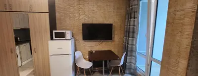 a small kitchen with a table and a tv on a wall at Colonel apartment 959 in Sofia