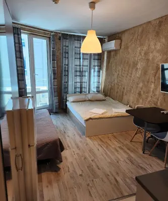 a bedroom with a bed and a desk and a tv at Colonel apartment 963 in Sofia