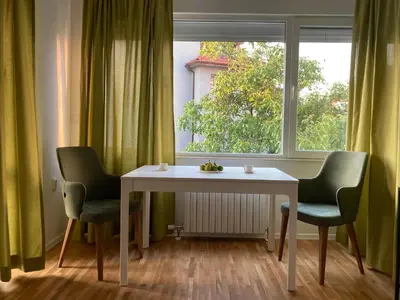 a table and two chairs in front of a window at Orfey Apartment in Sofia