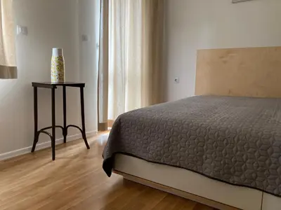 a bedroom with a bed and a vase on a table at Orfey Apartment in Sofia