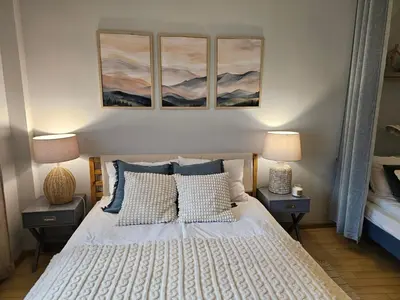 a bedroom with a bed with three paintings on the wall at S íRMA Apartment - The Soul of Central Sofia in Sofia