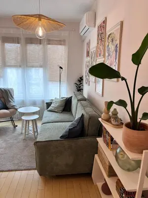 a living room with a couch and a potted plant at S íRMA Apartment - The Soul of Central Sofia in Sofia