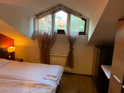a bedroom with a bed and a window with curtains at 7 apartments in Alexander complex in Bansko