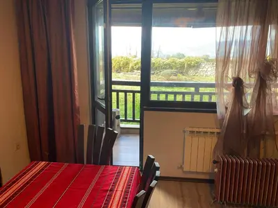 a room with a table and a large window at 7 apartments in Alexander complex in Bansko