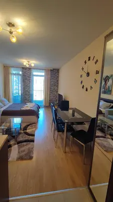 a living room with a large clock on the wall at Aspen Valley Studio Apartment Аспен Вали студио апартамент in Razlog