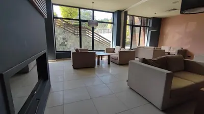 a waiting room with chairs and a table and windows at Aspen Valley Studio Apartment Аспен Вали студио апартамент in Razlog