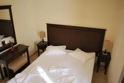 a bedroom with a large bed with white sheets and pillows at Spider House Aparthotel in Pamporovo