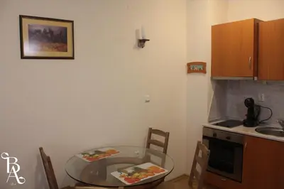a small kitchen with a glass table and a sink at Bansko Apart in Bansko