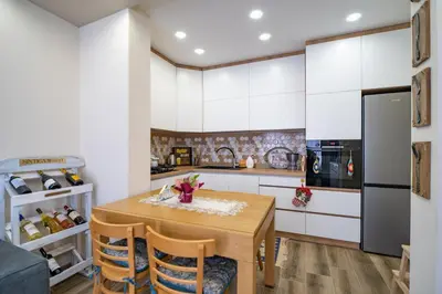 a kitchen with a wooden table and a refrigerator at MARSY in Sandanski