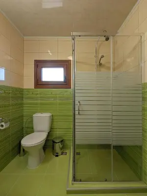a bathroom with a toilet and a glass shower at Къща за гости Феникс in Koprivshtitsa