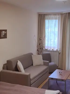 a living room with a couch and a table at Family Studio 302, Villa park in Borovets