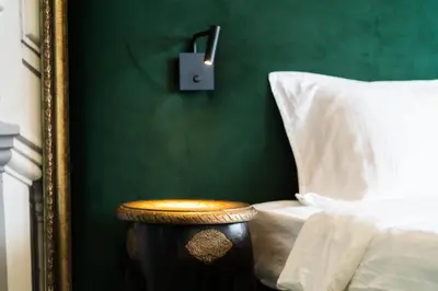 a bedroom with a bed and a wooden stool next to a mirror at Heart of the City Center Lux Apartment2 with View in Sofia