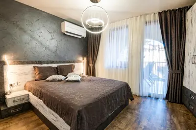 a bedroom with a large bed and a large window at Luxe Apartment Grand Monastery in Pamporovo in Pamporovo