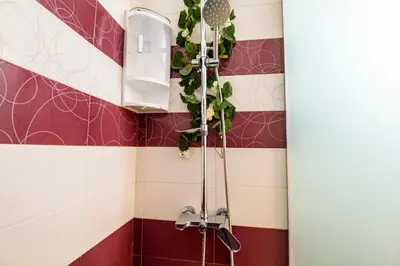 a bathroom with a shower with red and white tiles at Luxe Apartment Grand Monastery in Pamporovo in Pamporovo