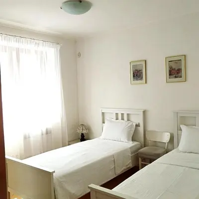 two beds in a small room with a window at Villa Magicland in Sofia