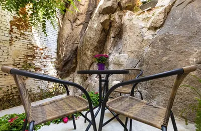 two chairs and a table in front of a rock wall at The Old Town Vintage 2-Bedroom Jewel by Flat Mаnager in Plovdiv