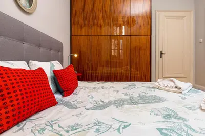 a bedroom with a bed with red pillows on it at The Old Town Vintage 2-Bedroom Jewel by Flat Mаnager in Plovdiv