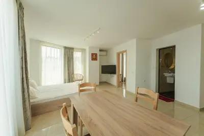 a living room with a wooden table and chairs at апартаменти Пасажио in Sandanski