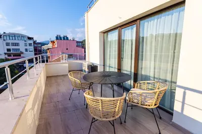 a patio with a table and chairs on a balcony at апартаменти Пасажио in Sandanski