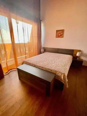 a bedroom with a bed and a large window at Pirin Golf Penthouse Iliyana in Bansko