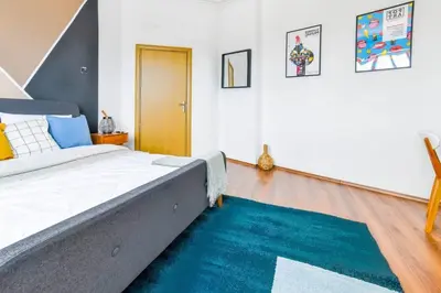 a bedroom with a large bed and a blue rug at 3 Rooms Together Budget Central Stay in Sofia