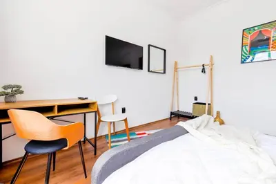 a bedroom with a bed and a desk and chairs at 3 Rooms Together Budget Central Stay in Sofia