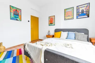 a bedroom with a large bed with colorful pillows at 3 Rooms Together Budget Central Stay in Sofia