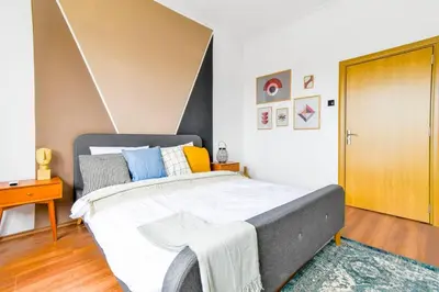 a bedroom with a large bed and a wooden door at 3 Rooms Together Budget Central Stay in Sofia