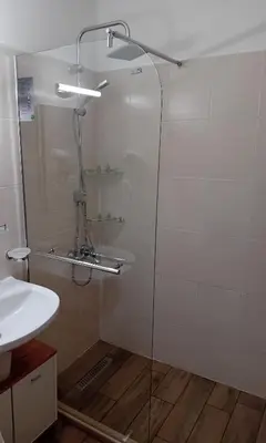 a shower with a glass door next to a sink at Borovets Ski&Spa Studio - Semiramida Garden A16 in Borovets