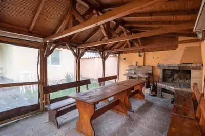 a wooden bench in a room with a fireplace at Вили Тихия Кът in Ribarica