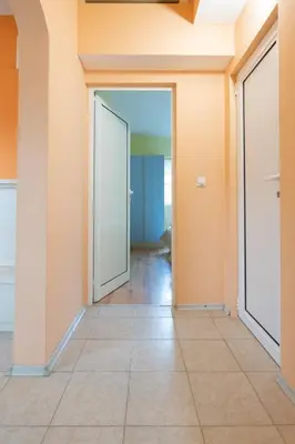 an empty hallway with orange walls and a door at Вили Тихия Кът in Ribarica